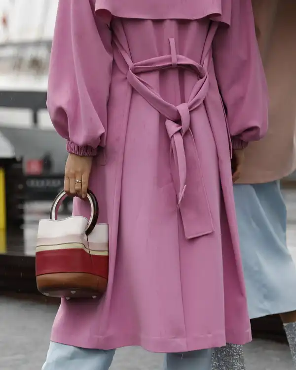 The back of a rose pink coat with a tie belt and gathered cuffs